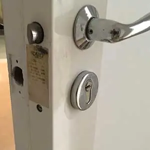 Cylindre et poignée d’une porte d’appartement avant changement de serrure à Paris