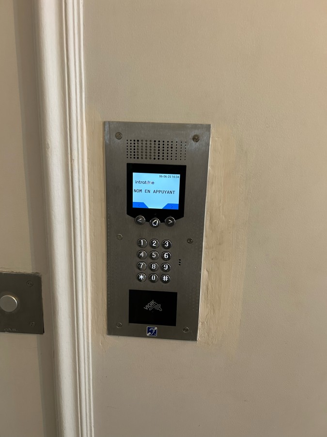 Platine d’interphone vidéo installée sur la façade d’un immeuble parisien