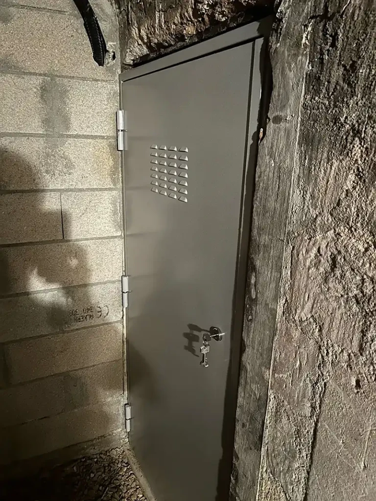 Porte de cave sur mesure en acier installée dans une cave voûtée parisienne