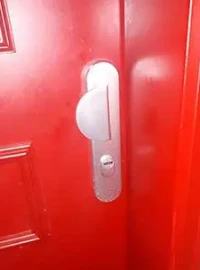 Poignée et serrure sur une porte d’entrée rouge à Paris